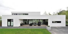 a large white house sitting on top of a lush green field