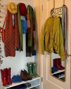 a closet filled with lots of different types of clothes and boots hanging on the wall