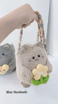 two crocheted purses with cats on them, one is holding a banana