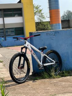 a white bicycle leaning against a blue wall