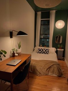 a bed room with a neatly made bed and a laptop computer on a wooden desk