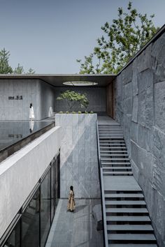 a woman walking up the stairs in front of a building