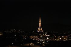 the eiffel tower is lit up at night