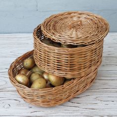 two wicker baskets filled with apples on top of a wooden table