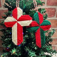 two crocheted crosses hanging from a christmas tree