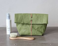 a wooden toothbrush sitting next to a green bag