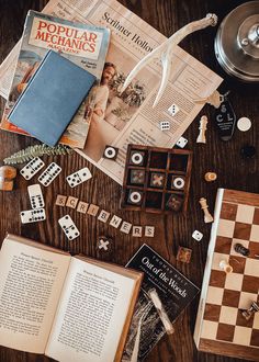 an open book sitting on top of a wooden table next to dice and other items