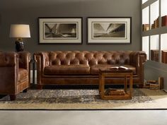 a living room with leather furniture and pictures on the wall