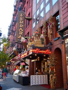 people are walking down the street in front of a building with many decorations on it