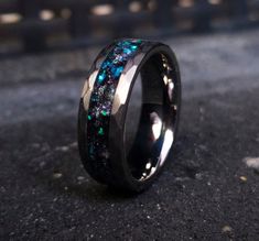 a wedding ring with blue and green stones inlayed to it's surface