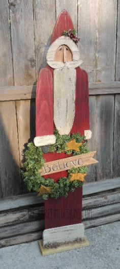 a wooden santa clause holding a wreath