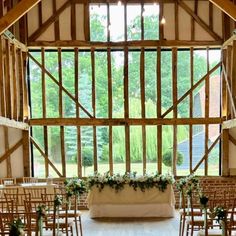 the inside of a barn with rows of chairs and tables set up for an event