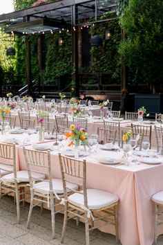 an outdoor dining area with tables and chairs set up for a formal dinner or party