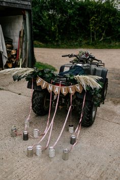 an atv decorated with flowers and candles for a birthday party on the ground in front of a garage