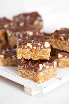 several pieces of chocolate peanut butter bars stacked on top of each other