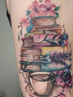 a tattoo with books and a cup on it