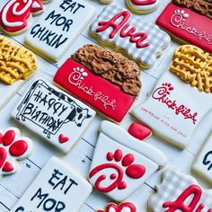 many decorated cookies are displayed on a table top with the words happy birthday written in red, white and black