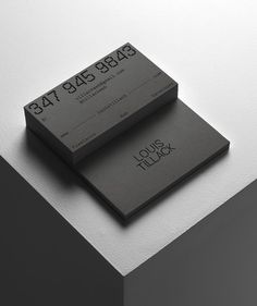 two black and white business cards sitting on top of each other next to each other