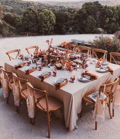 an outdoor table set with plates and place settings