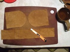 the cutting board is made out of brown paper and has two circles cut out on it