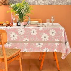 the table is set for two with plates and glasses on it, next to a vase full of flowers