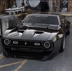 a black muscle car parked in front of a brick building with graffiti on the walls