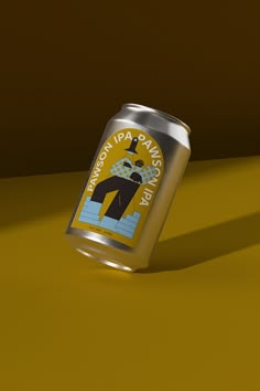 a can of beer sitting on top of a yellow table