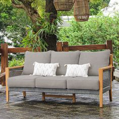 a couch sitting under a tree on top of a patio