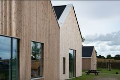 a row of wooden buildings sitting next to each other on top of a grass covered field