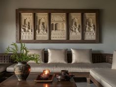 a living room filled with furniture and paintings on the wall above it's coffee table