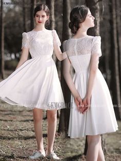 two women in white dresses standing next to each other with their hands on their hips