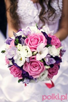 a bride holding a bouquet of pink and white flowers