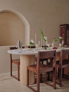 the table is set with flowers and place settings for two people to sit at it