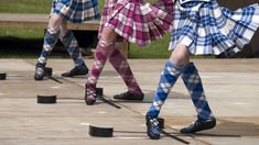 three women in plaid skirts are performing on stage