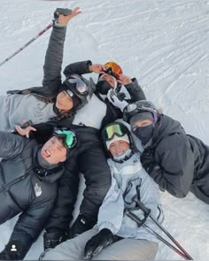 a group of people laying on top of each other in the snow