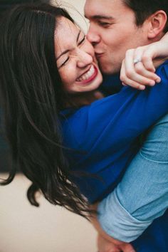 a man and woman are hugging each other