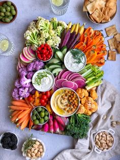 a table topped with lots of different types of vegetables and dips on top of each other