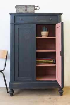 a blue cabinet with pink doors and shelves