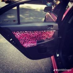 the interior of a car is decorated with pink and black leopard print fabric, while the door panels are open