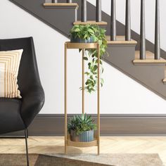 a living room with a chair, plant stand and stair case in the corner next to stairs