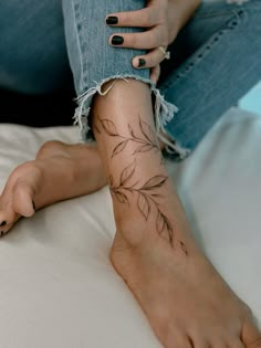 a woman's leg with a flower tattoo on her left arm and right foot