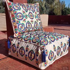 an ornately decorated couch with tassels on it's back and sides