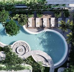 an aerial view of a swimming pool with lounge chairs and trees surrounding the pool area