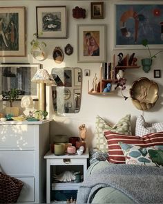 a bed room with a neatly made bed and lots of pictures on the wall above it