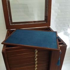 a wooden jewelry box with blue velvet inside