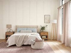 a bedroom with white walls and wooden floors