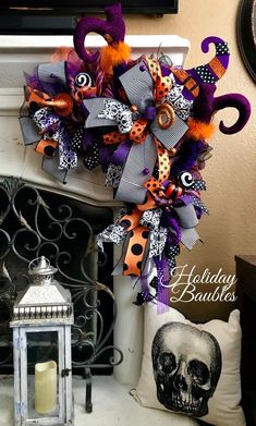 a halloween wreath is hanging on the mantle next to a fire place with a candle