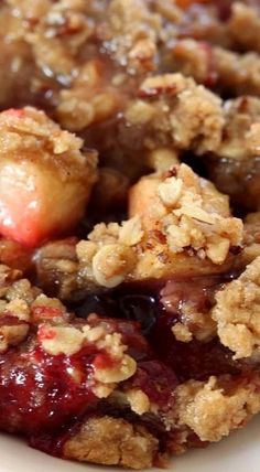 a close up of a plate of food with fruit and crumbs on it