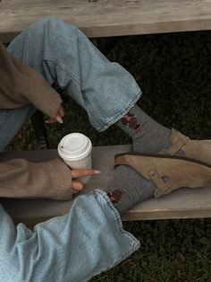 Girl sitting on a park bench in a park with green and fall foliage, holding a Starbucks cup wearing light denim jeans, and Birkenstock Bostons with Polo Ralph Lauren bear socks and a cozy off the shoulder sweater Fall Photo Poses, Coffee Autumn Aesthetic, Polo Bear Socks, Potato Shoes, Clog Outfit, Boston Soft Footbed, Bear Socks, Coffee Photo, Socks Aesthetic