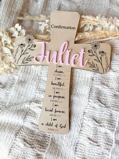 a wooden cross with the words jubilee written on it and flowers in pink lettering next to it